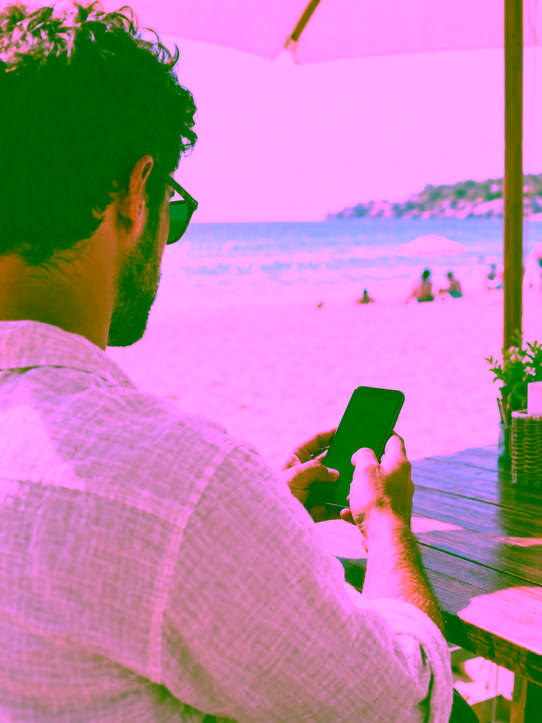 Empresário acompanhando a empresa pelo celular na praia